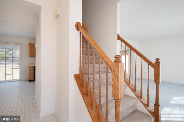 staircase featuring tile patterned floors and baseboards