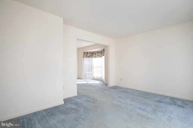 spare room featuring baseboards and carpet floors