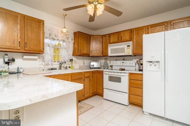 kitchen with white appliances, light countertops, a peninsula, and a sink