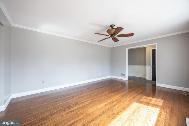 unfurnished room featuring visible vents, a ceiling fan, wood finished floors, crown molding, and baseboards