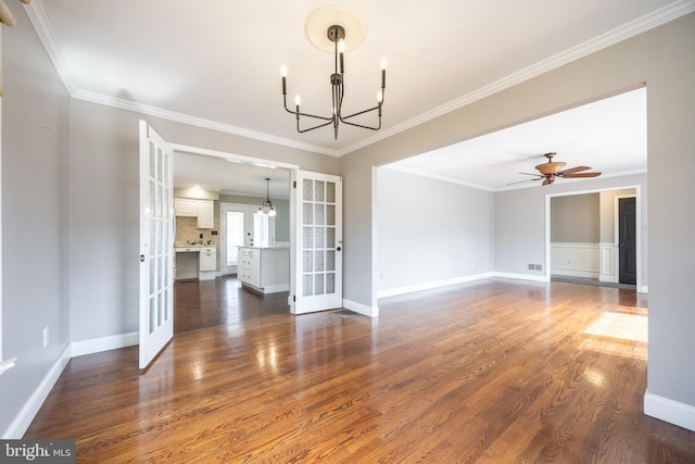 unfurnished room with baseboards, ornamental molding, dark wood-type flooring, french doors, and ceiling fan with notable chandelier