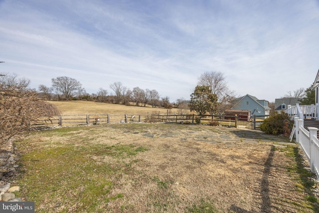 view of yard featuring a rural view and fence