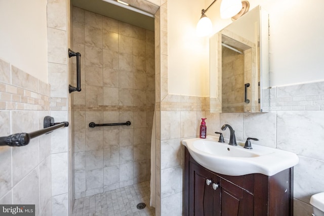 full bathroom with toilet, tile walls, a stall shower, and vanity