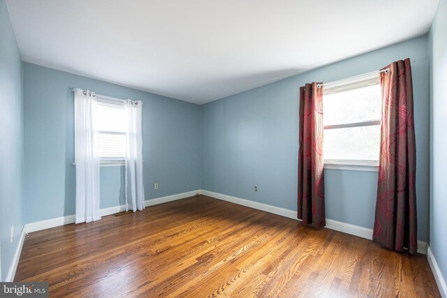 unfurnished room with baseboards and wood finished floors