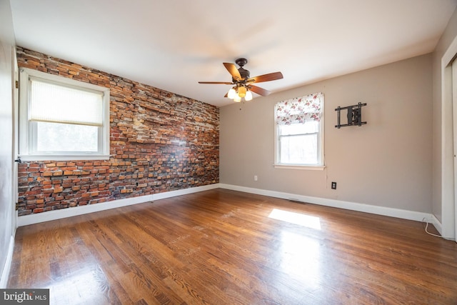 unfurnished room featuring ceiling fan, baseboards, and wood finished floors