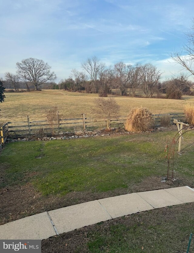 view of yard featuring a rural view and fence