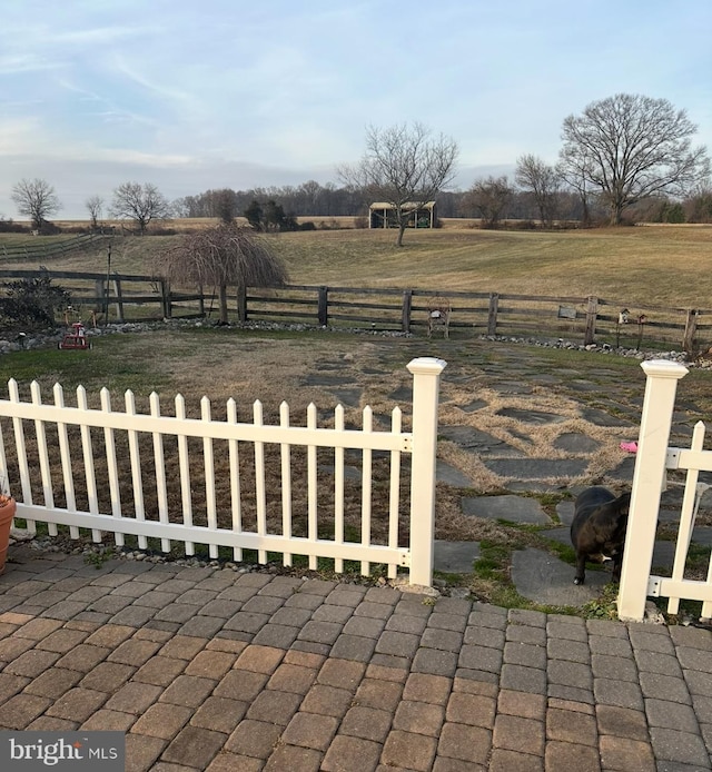 view of yard with a rural view and fence