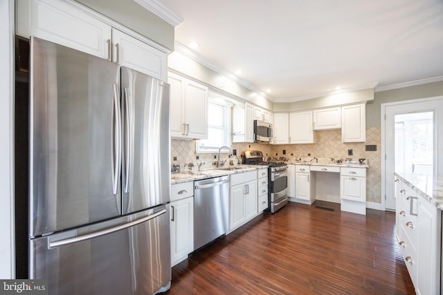 kitchen with crown molding, dark wood finished floors, white cabinets, stainless steel appliances, and a sink