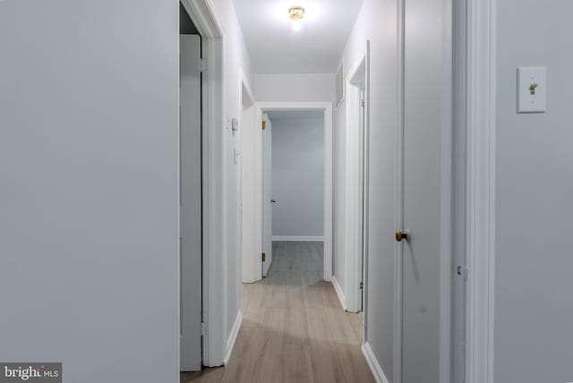 hallway with baseboards and light wood-style flooring