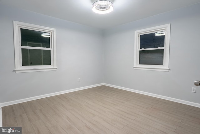 unfurnished room with baseboards and wood finished floors