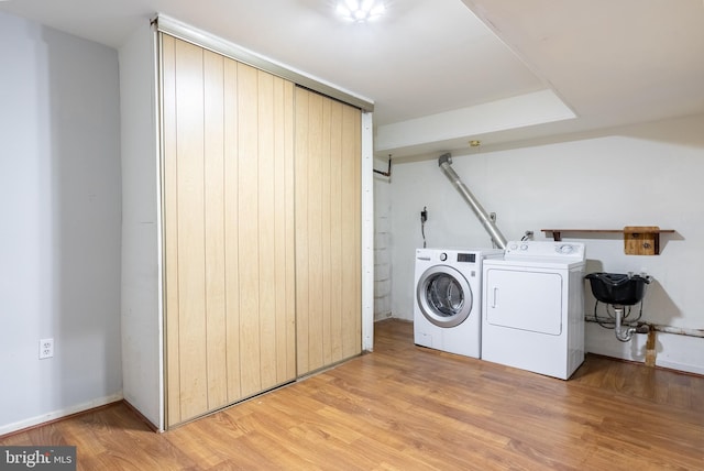 washroom with light wood-style floors, laundry area, and washing machine and clothes dryer