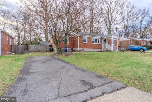 bungalow-style home with crawl space, brick siding, a front lawn, and fence