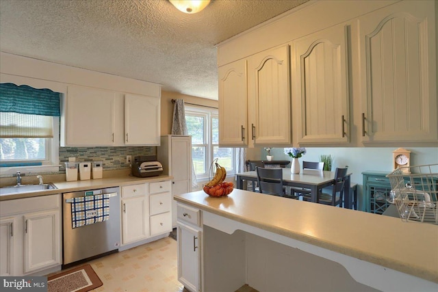 kitchen featuring a sink, white cabinetry, light countertops, light floors, and dishwasher