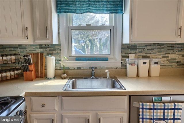 kitchen with light countertops, white cabinets, and a sink