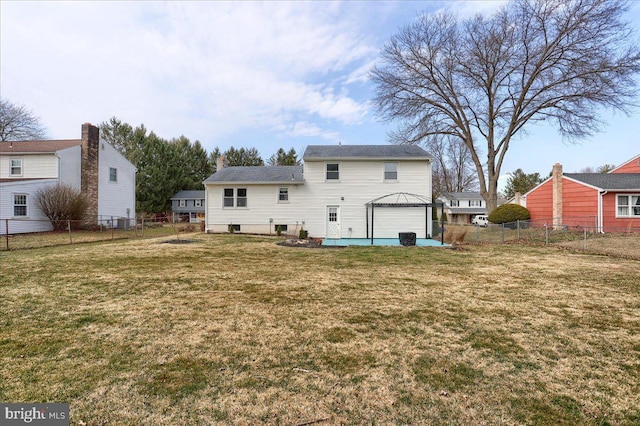 rear view of house featuring a yard and a fenced backyard