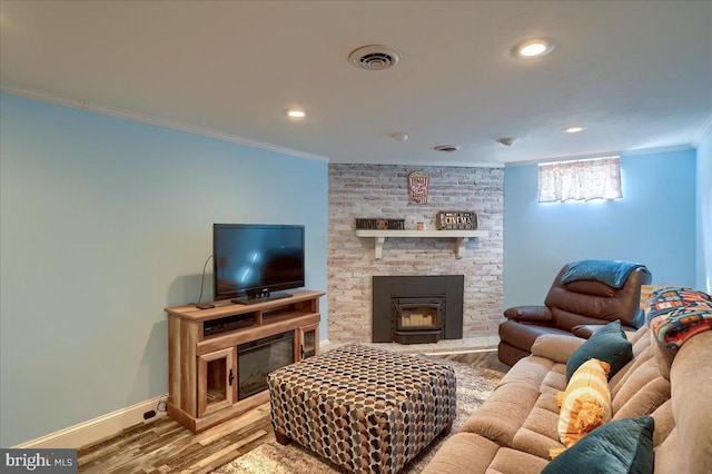 living area featuring visible vents, wood finished floors, recessed lighting, crown molding, and baseboards