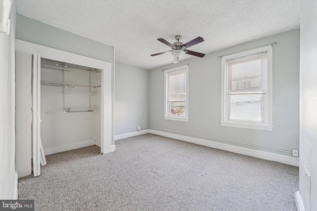 unfurnished bedroom with a ceiling fan, baseboards, carpet floors, a closet, and a textured ceiling