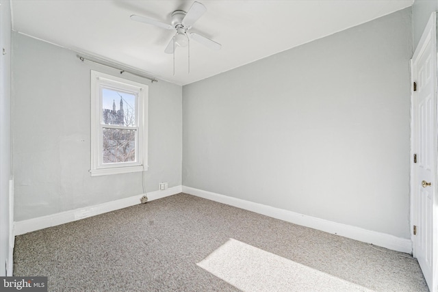 carpeted spare room with baseboards and a ceiling fan