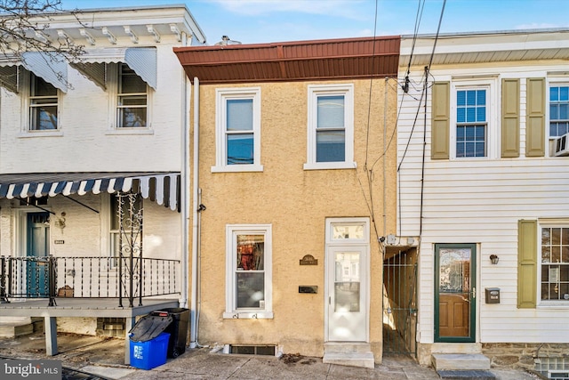 view of property featuring a porch and stucco siding