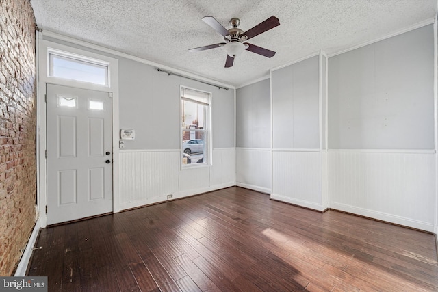 foyer entrance with wood-type flooring, a textured ceiling, and ornamental molding