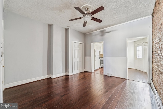 empty room featuring hardwood / wood-style floors, a ceiling fan, and a textured ceiling