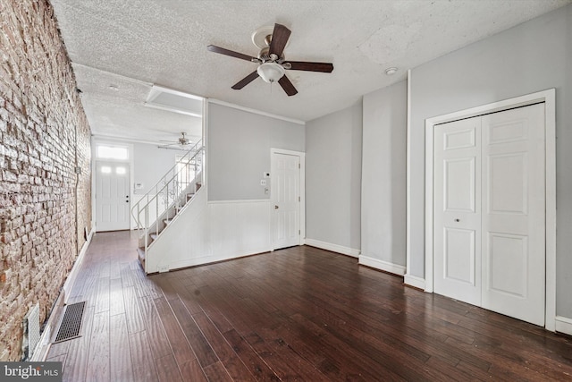 unfurnished living room featuring visible vents, a ceiling fan, hardwood / wood-style flooring, a textured ceiling, and stairway