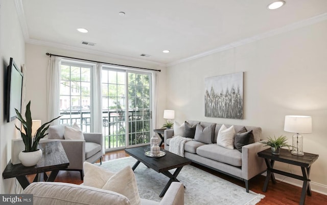 living room featuring wood finished floors, baseboards, visible vents, recessed lighting, and crown molding