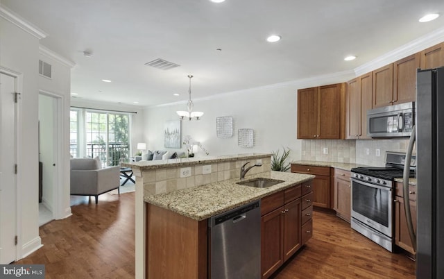 kitchen with a sink, ornamental molding, and stainless steel appliances