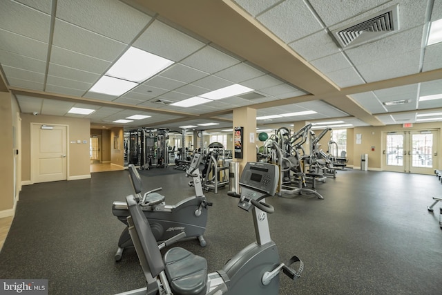 workout area with baseboards, visible vents, and a drop ceiling