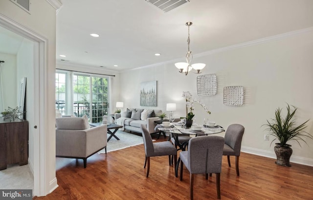 dining area with visible vents, wood finished floors, and crown molding