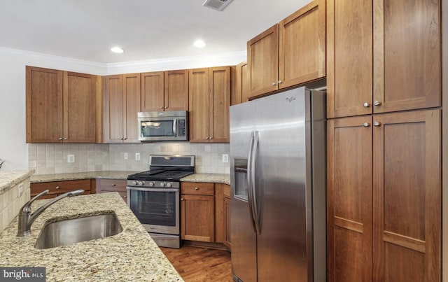 kitchen featuring a sink, backsplash, appliances with stainless steel finishes, and dark wood-style flooring