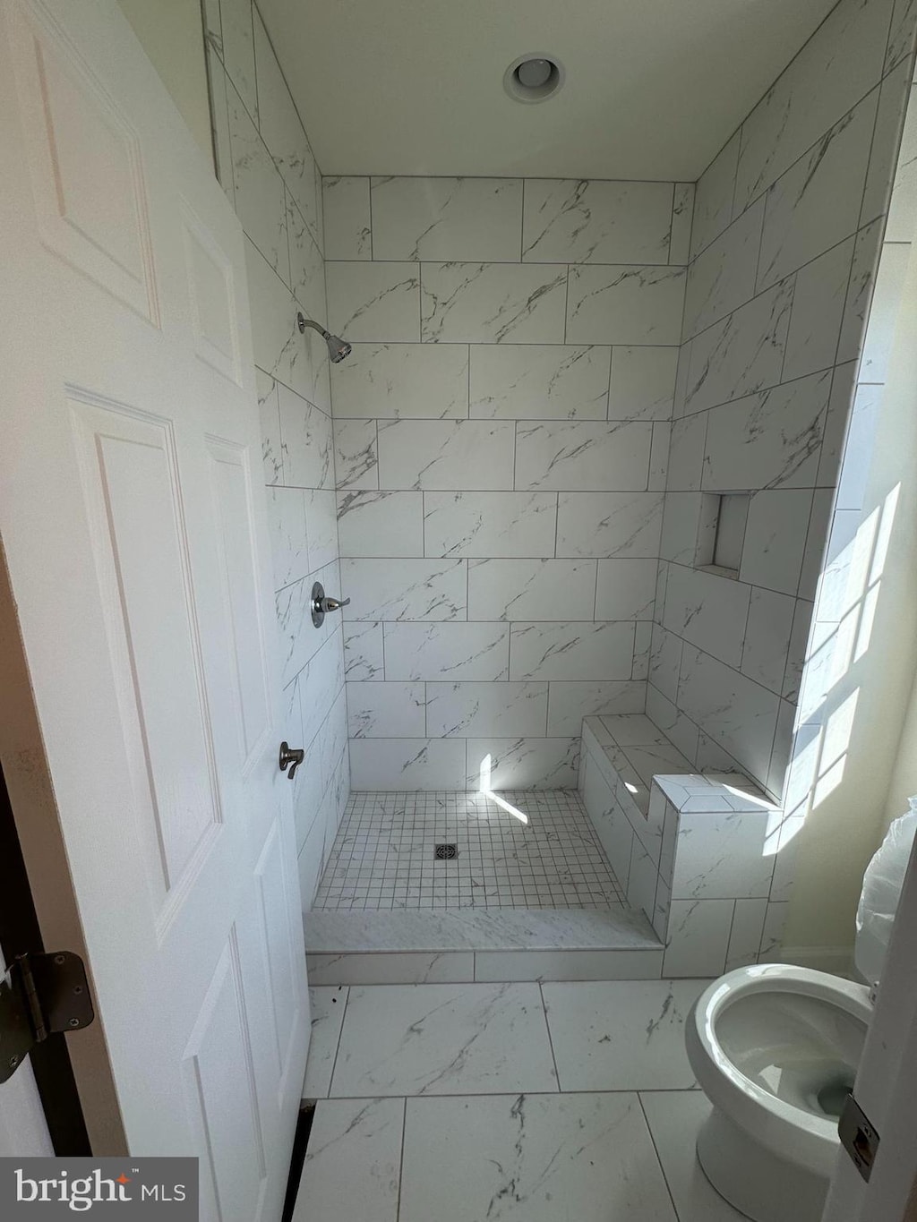 full bathroom featuring a shower stall, toilet, and marble finish floor