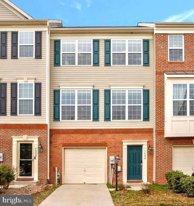 townhome / multi-family property with concrete driveway, an attached garage, and brick siding