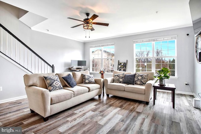 living room with baseboards, wood finished floors, ceiling fan, and crown molding