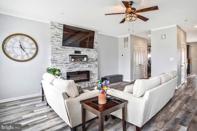 living room featuring visible vents, baseboards, a ceiling fan, and wood finished floors