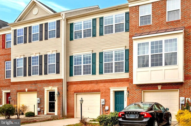 multi unit property featuring brick siding, a garage, and driveway