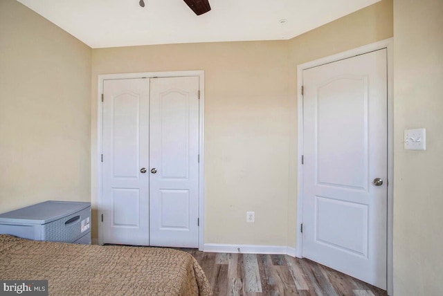 bedroom featuring a closet, ceiling fan, baseboards, and wood finished floors