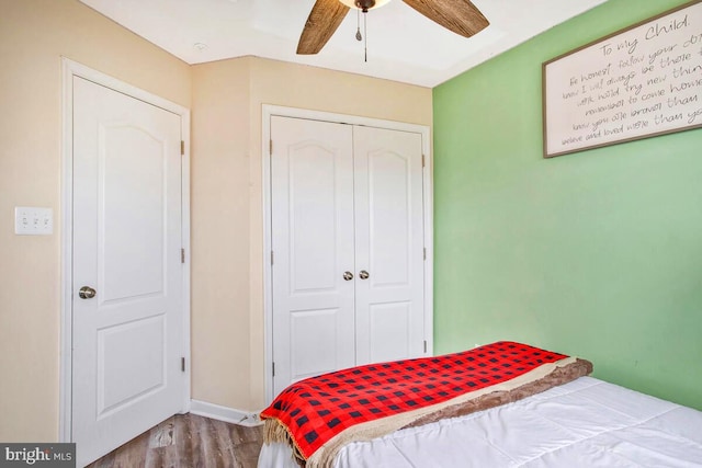 bedroom featuring a ceiling fan, wood finished floors, and a closet