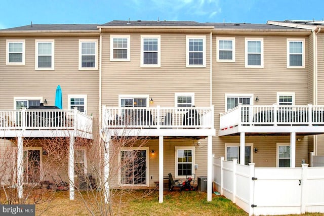 rear view of house featuring cooling unit, a wooden deck, and fence