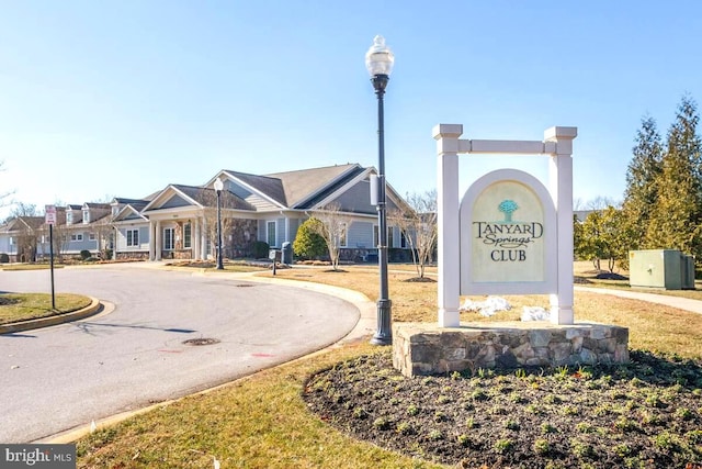 community sign featuring curved driveway