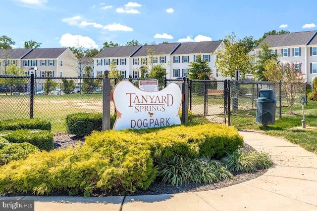 community / neighborhood sign with a residential view and fence