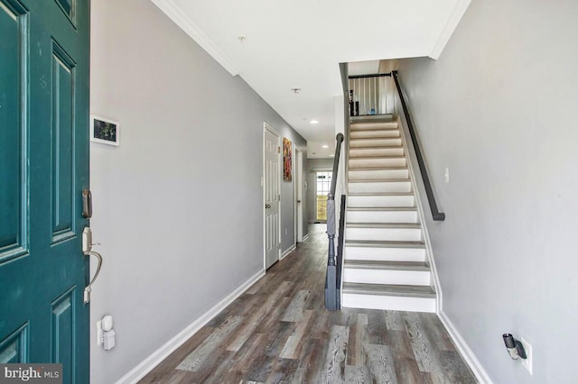 foyer featuring stairway, ornamental molding, baseboards, and wood finished floors