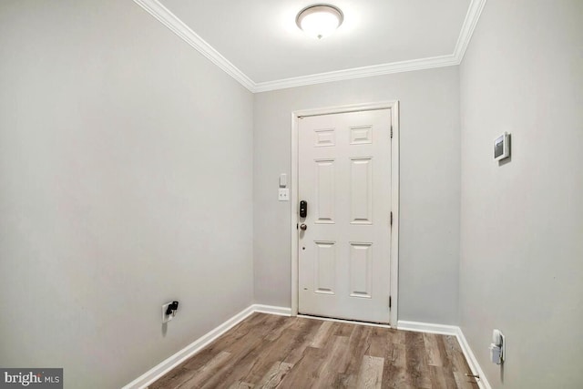 entryway featuring crown molding, wood finished floors, and baseboards