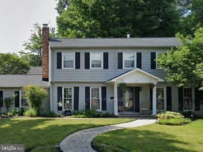 colonial home with a front lawn and a chimney