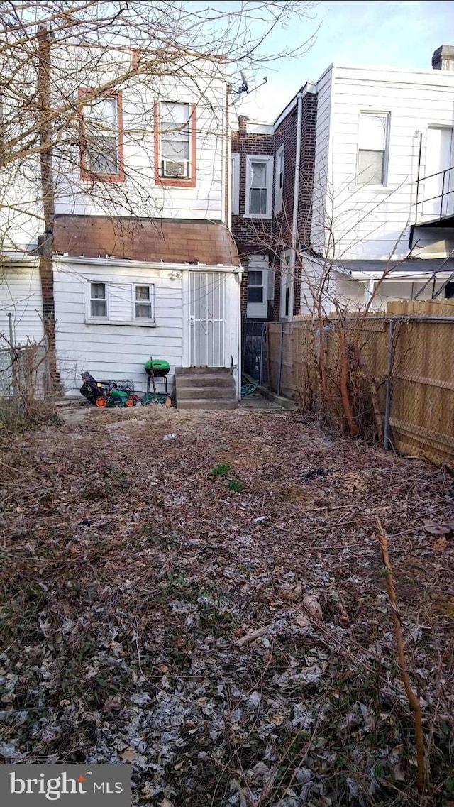 back of property featuring cooling unit, entry steps, and fence