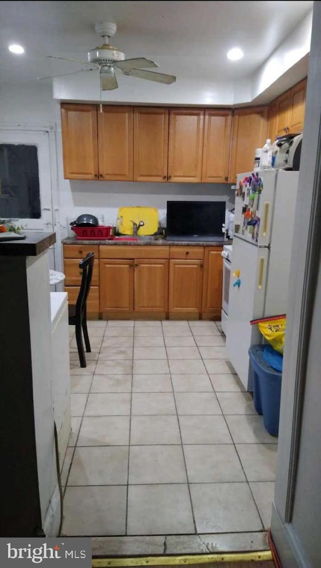 kitchen with white appliances, light tile patterned floors, brown cabinetry, recessed lighting, and ceiling fan