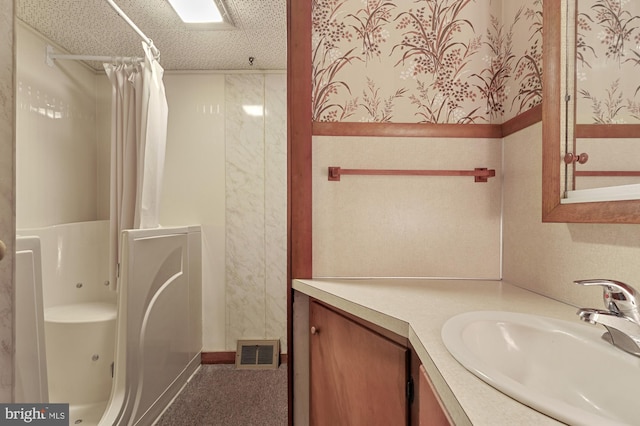 bathroom featuring vanity, a shower with curtain, visible vents, wallpapered walls, and a textured ceiling