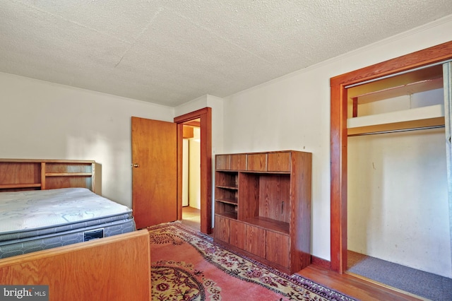 bedroom with wood finished floors and a textured ceiling