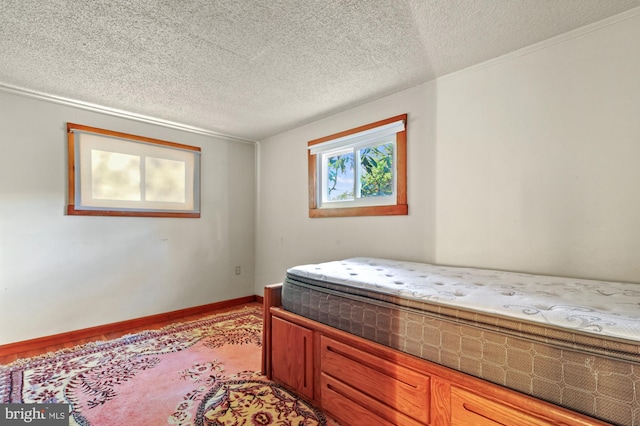 bedroom with baseboards and a textured ceiling