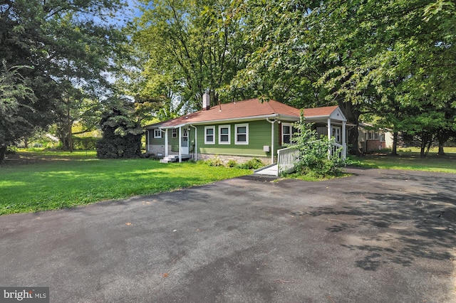 view of front facade with entry steps, driveway, and a front yard